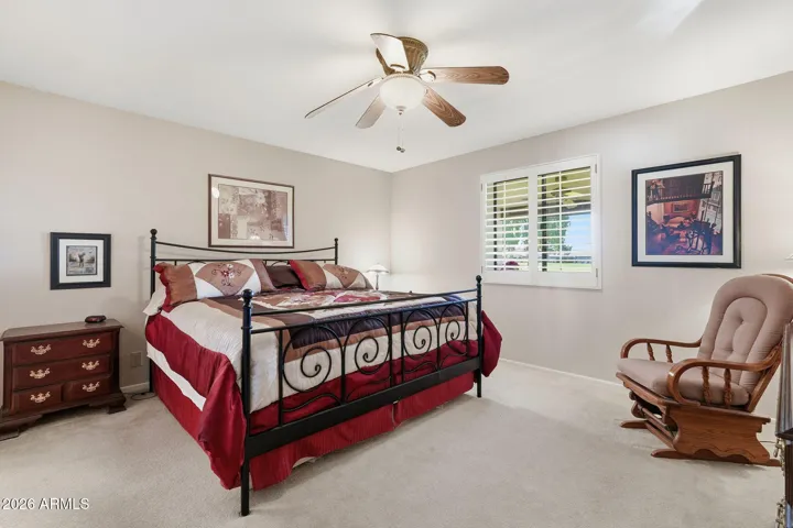 Primary bedroom with south-facing window providing golf course views.