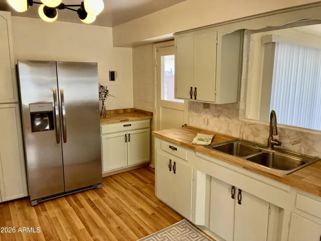 New Stainless Steel Side-by-Side Refrigerator with Water and Ice in the Door. Solid Wood Countertops, New Sink, and Stunning Tile Backsplash.