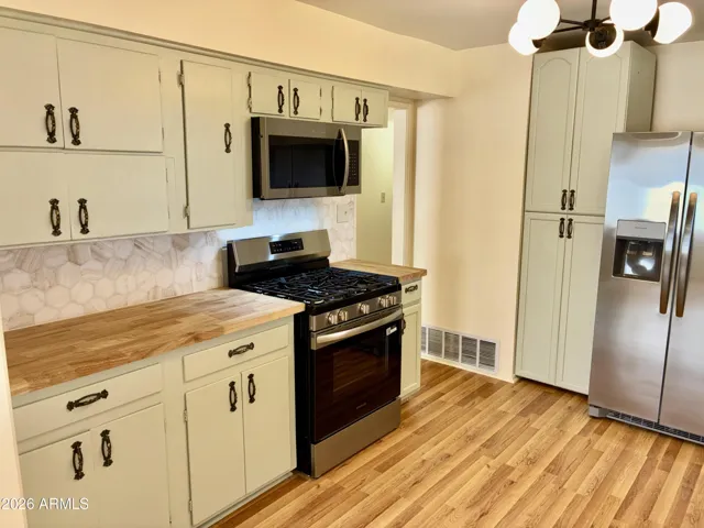 Remodeled Kitchen Featuring ALL NEW Stainless Steel Appliances, New Solid Wood Countertops, Stunning Tile Backsplash, and Fresh Vinyl Plank Flooring.