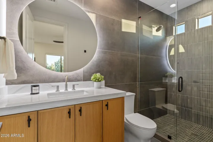 Secondary Bathroom with large shower and backlit mirror