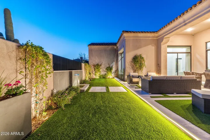Large turf area in the backyard with water feature