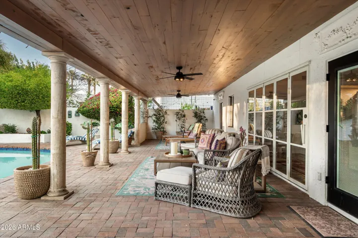 A covered patio where filtered light and open air create a shaded retreat for gathering, lingering, and quiet repose