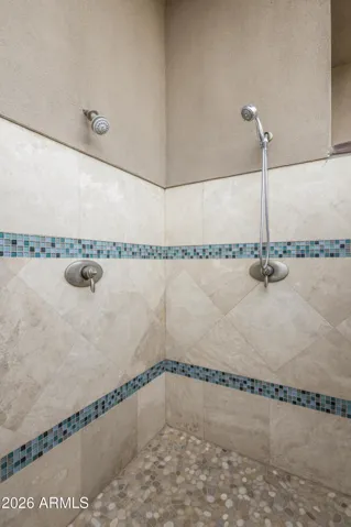 Outdoor pool shower with two shower heads. Hand shower provides easy use as a dog wash, too!