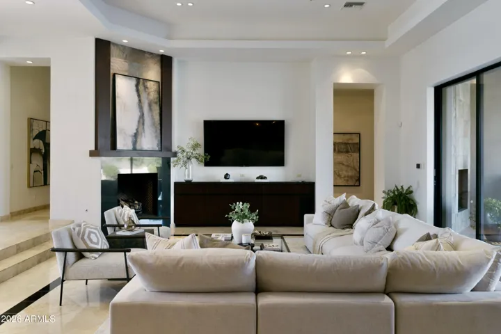 Gas fireplace for cozy moments and steps from the foyer. Primary bedroom entrance on the right.