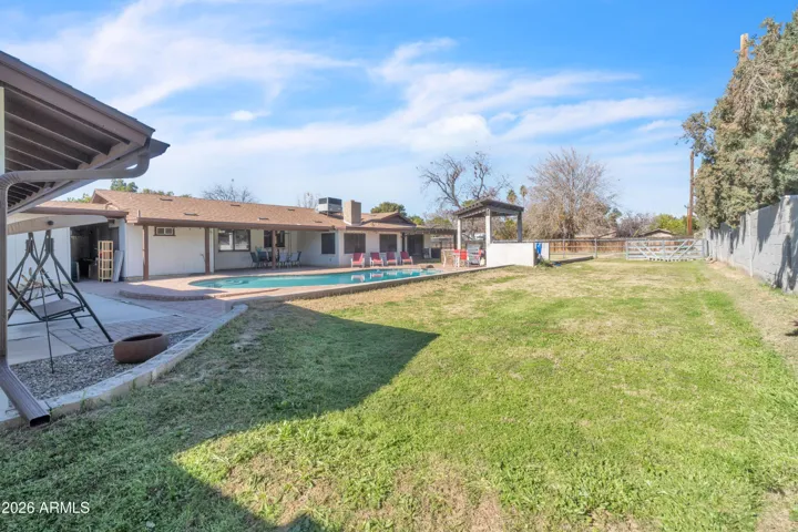This is the backyard buyers dream about — real grass, wide-open space, poolside living, and room for the moments that matter.