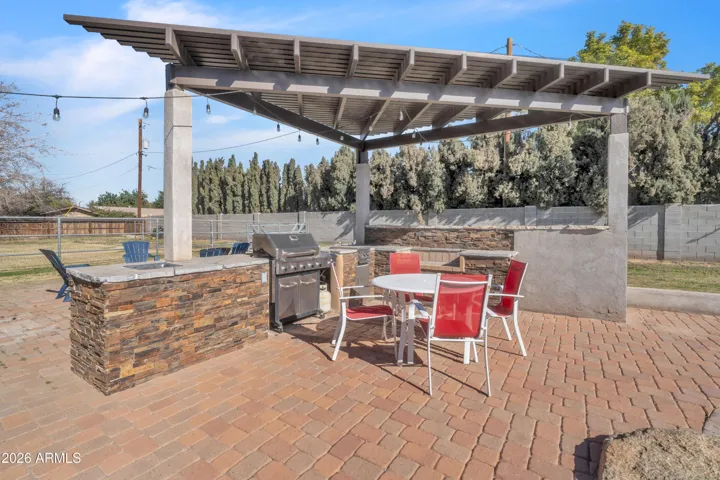 This is where the backyard comes together — shaded dining, BBQ nearby, and poolside living made easy.