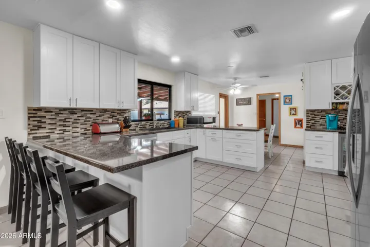 Remodeled main house kitchen with new appliances, coffee bar, beverage fridge, sink window, and connection to the fireplace living area.