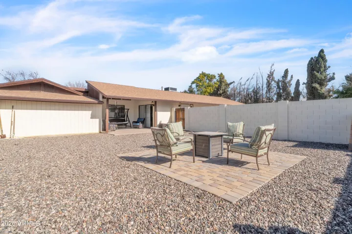 Private guest house backyard with low-maintenance rock and a paver patio area for outdoor seating or a small gathering space.