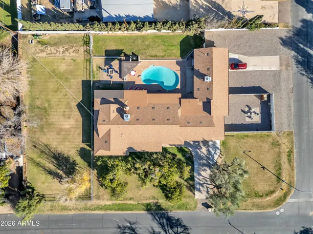 Overhead aerial view showcasing the full property layout — main home, detached guest house, pool, ramada, grass area, pasture, and overall usable space.