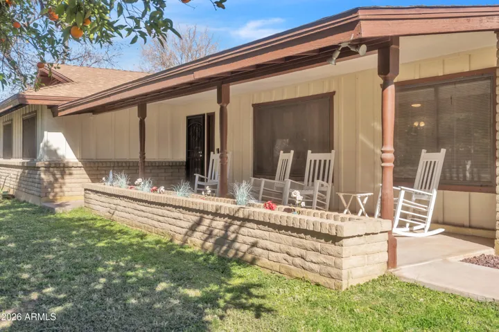 This is the kind of front porch buyers dream about — rocking chairs, citrus trees, and room to slow down and enjoy the property.