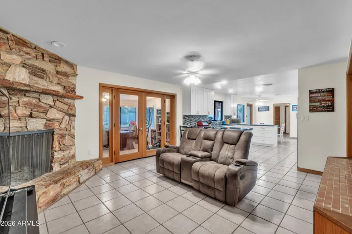 Fireplace living area connected to a spacious den, offering flexible space for relaxing, gathering, hobbies, or office use.