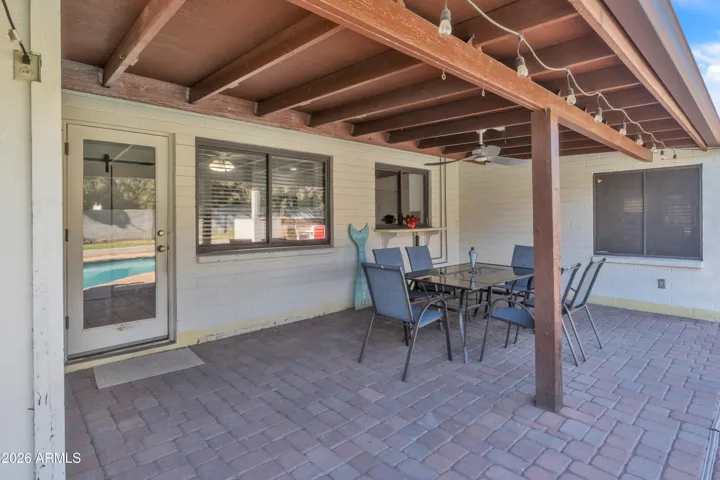 Indoor-outdoor living made easy — covered patio seating, poolside access, and a kitchen pass-through for serving, gathering, and entertaining.