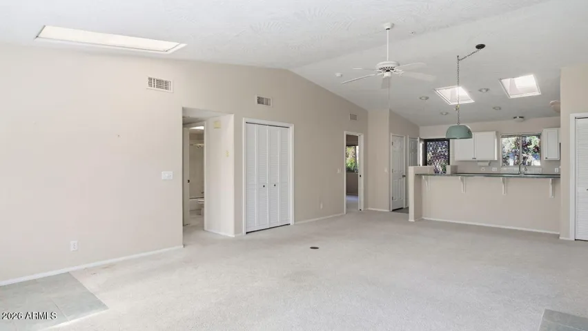 Dining area and kitchen to the right. Left door to the guest room; door on the right to the primary suite.