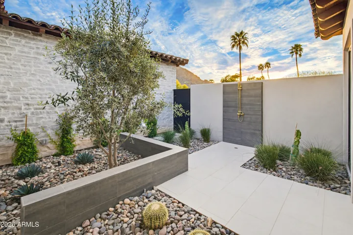 Private garden and outdoor shower through sliding door from Primary bath