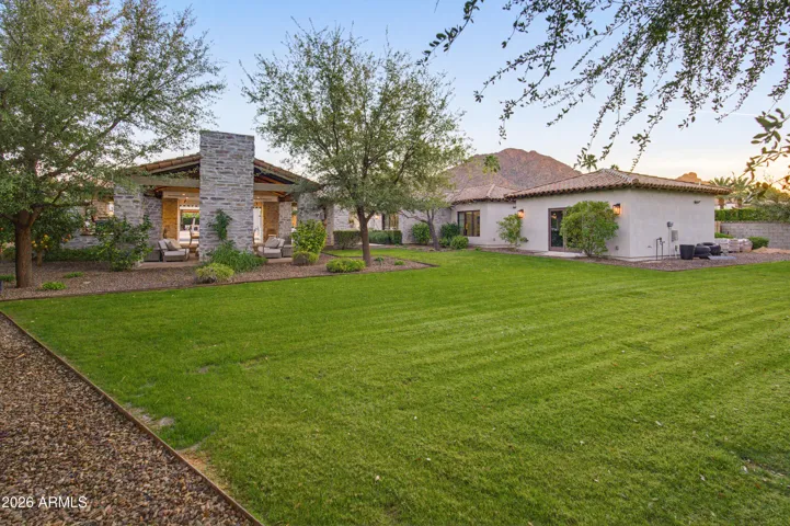 Lush lawn in backyard by outdoor pavilion