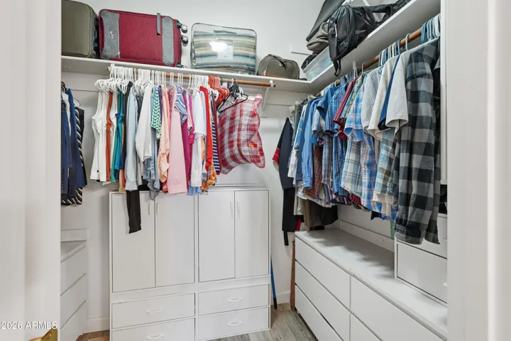 Huge walk in closet with built-ins and laundry shoot.