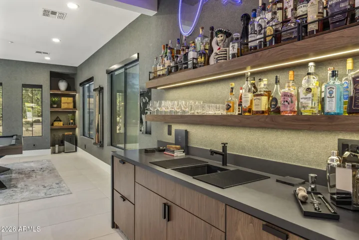 Featuring floor-to-ceiling custom tile feature wall with floating shelves and integrated lighting