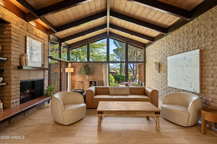 Mid-mod vibes shine through in this room with exposed buff colored slump-block, vaulted beam and plank ceilings ensuring the heritage of the vernacular is ever present.