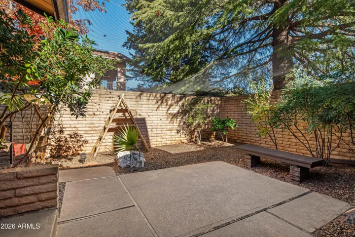A quaint space, shaded by an amazing evergreen, accessed by the living room and primary suite.
