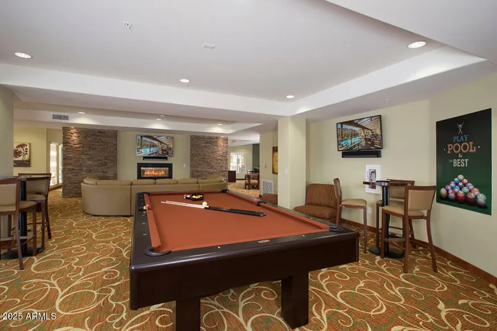 Unwind with neighbors in the community clubhouse featuring a fireplace, pool table, and TVs—designed for entertainment, connection, and relaxation in resort-style comfort.