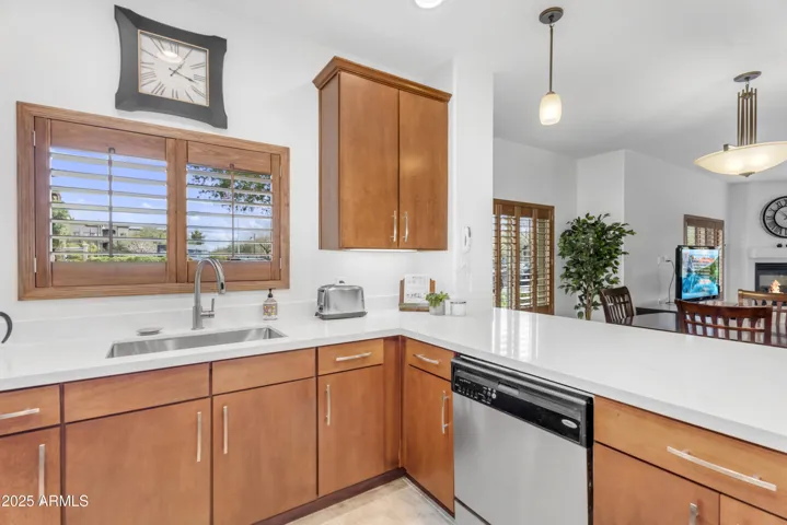 Enjoy stunning outdoor views while cooking in this bright and airy kitchen, complete with updated cabinets, modern fixtures, and sleek quartz countertops. The window above the sink adds charm and natural light, highlighting the energy-efficient stainless steel appliances.