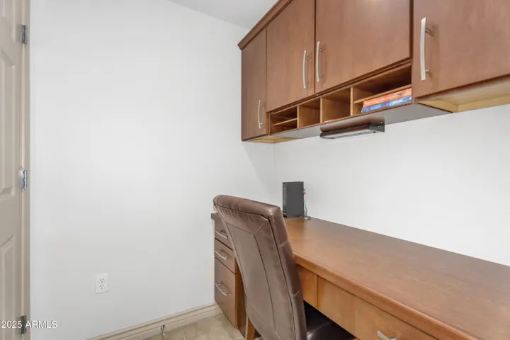 This efficient office nook is perfect for remote work or creative projects, offering custom cabinets, built-in lighting, and a full desk in this well-designed Arizona condo.