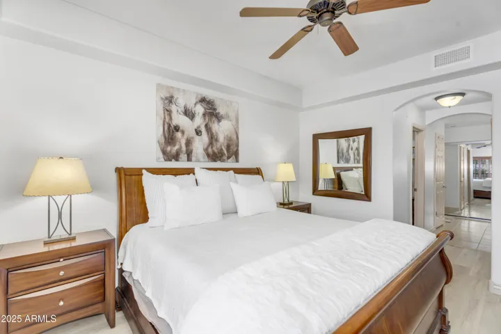 The primary bedroom offers serene comfort with elegant tray ceilings, wood shutters, and ample natural light. The oversized layout provides plenty of space to unwind, complete with private access to the luxurious en-suite bath.
