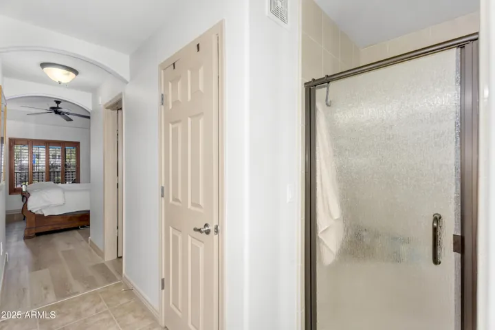 Enjoy privacy and convenience in the primary ensuite’s glass-enclosed walk-in shower with tile surround—a stylish and low-maintenance feature in this desert getaway.