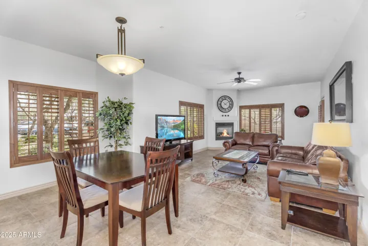 Spacious great room layout with abundant natural light, updated tile flooring, and access to a peaceful patio—ideal for relaxing or entertaining in sunny Phoenix.