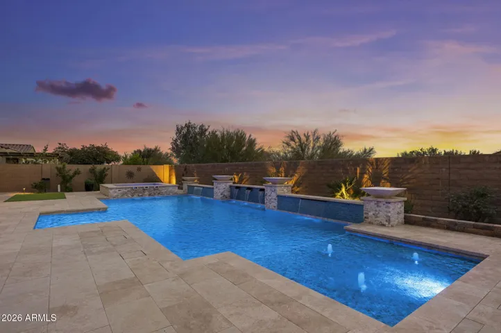 Resort-style heated pool and spa with saltwater system, travertine decking, water features, and landscape lighting—perfect for luxury golf community living in Blackstone at Vistancia.