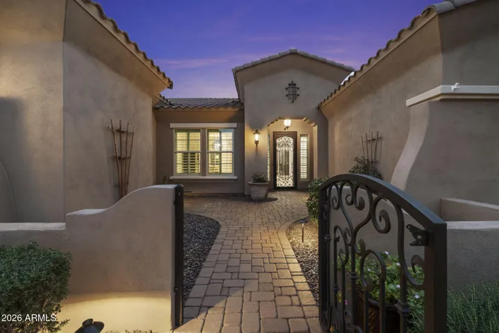 Private gated courtyard entry with paver walkway and custom iron gate, welcoming you into this luxury home at Blackstone in Vistancia.
