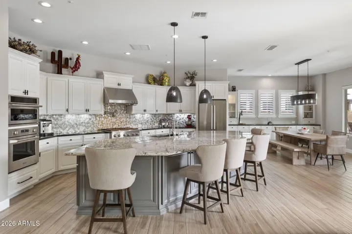 Open great room and gourmet kitchen with Bosch & Monogram appliances, painted cabinetry, designer lighting, and luxury finishes throughout.