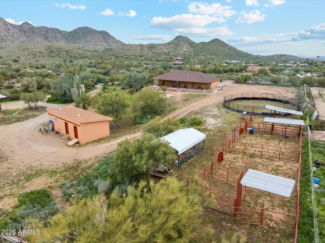 Tan building with 2 red doors is the Main Outbuilding. Do what you like with this room. Air conditioned, and currently set up as a painting and multi-use room. Have a nice place to keep your horses too with stalls and 51ft arena. Covered car port for parking or keeping your additional toys out of the sun.