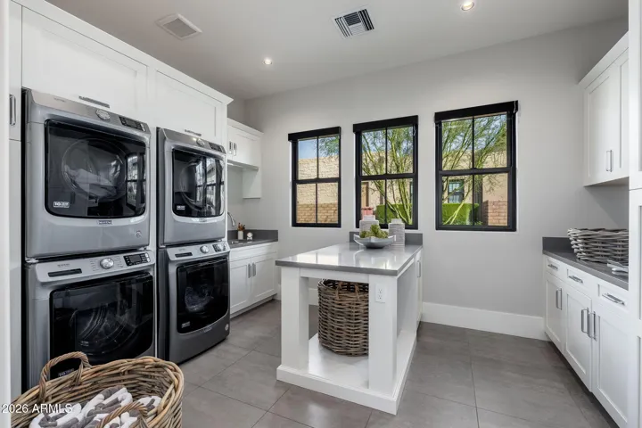 2 stacked washers & dryers in oversized laundry room