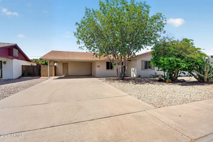 Inviting single-level Phoenix home with low-maintenance desert landscaping, mature trees, and an extended driveway leading to a covered carport. This remodeled property offers great curb appeal, energy-efficient dual pane windows, and no HOA—an exceptional opportunity in a well-established neighborhood.