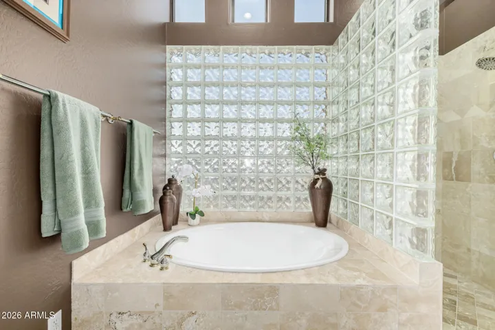Soak in the deep garden tub w/ polished travertine surround