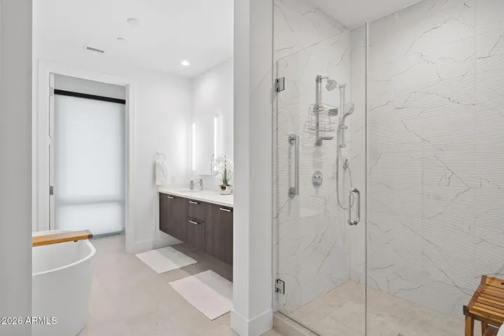 Luxurious primary bathroom with oversized walk-in shower and sleek contemporary design.
