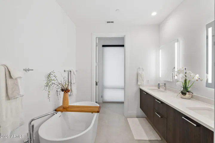 Spa-inspired primary bath with dual vanity, soaking tub, and modern finishes.
