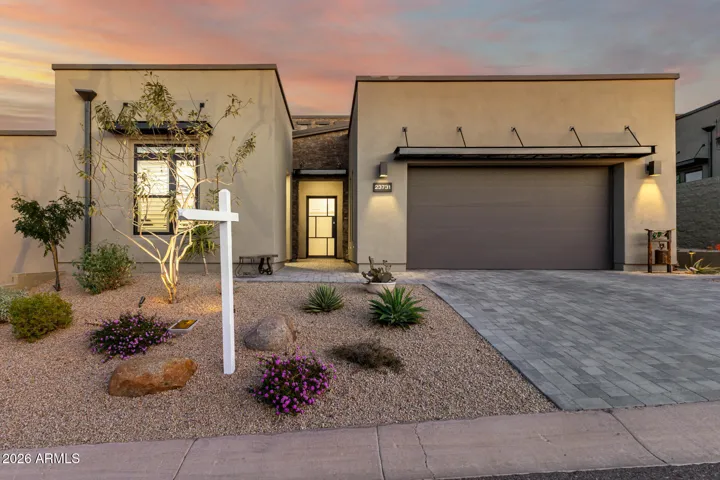 Great curb appeal with metal and stacked stone accents and paver driveway.