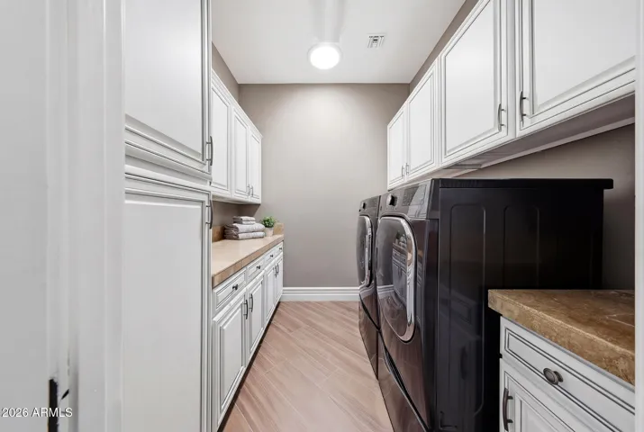 Dedicated laundry room with cabinetry and counter space