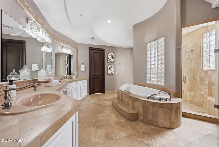 Spa-inspired bath with soaking tub and dual vanity. Large tiled shower with multiple shower heads, sprayers and glass block windows to bring in all the natural light.