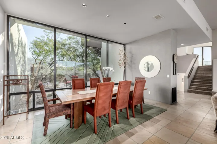 The seamlessly flowing living & dining room is paired with a fireplace and floor to ceiling windows.