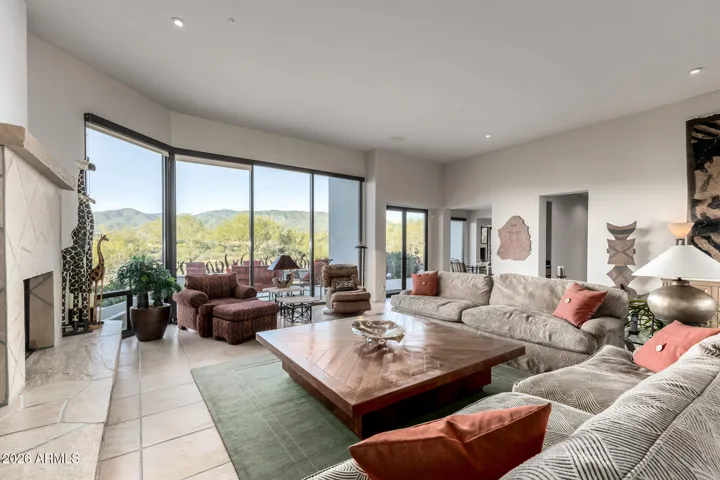 The seamlessly flowing living & dining room is paired with a fireplace and floor to ceiling windows.