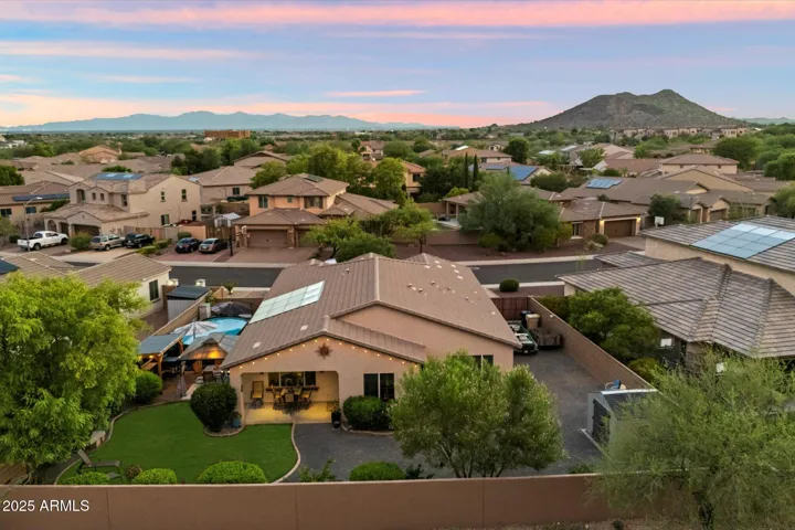 Enjoy stunning aerial views of this Peoria home set against picturesque mountain scenery and vibrant Arizona sunsets. The private backyard showcases lush landscaping, artificial turf, and a covered patio, all within a well-maintained neighborhood offering scenic surroundings and desirable location appeal.