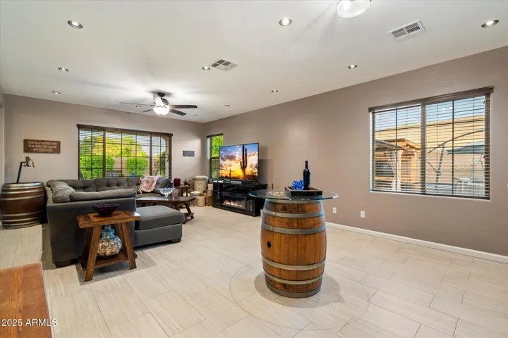 This expansive living room in Peoria offers recessed lighting, neutral tile flooring, and large windows that fill the space with natural light. The open layout connects effortlessly to the kitchen and dining areas, creating a functional and inviting atmosphere.