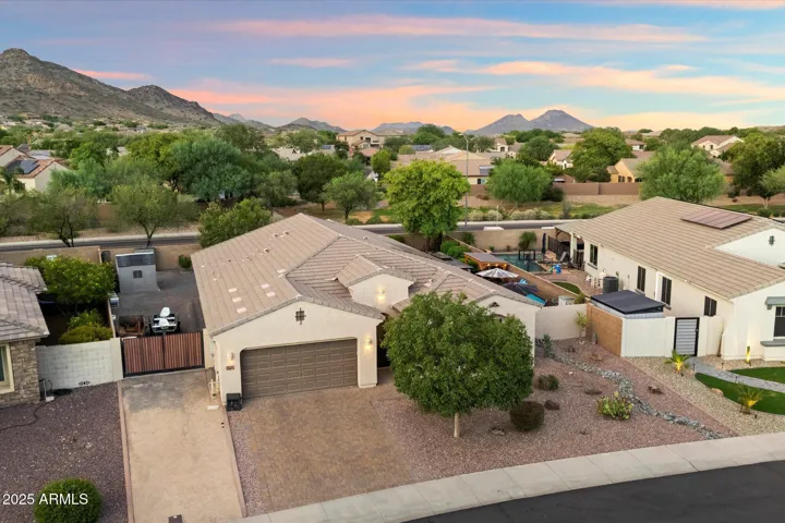 This drone view captures the home’s well-maintained exterior, extended driveway, and surrounding Peoria neighborhood with scenic mountain views. The spacious lot and desert landscaping add to the property’s curb appeal.