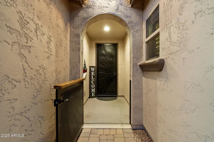 The private gated courtyard entry welcomes you into this Peoria home with textured stucco walls and a custom security door. This covered entrance adds charm, privacy, and enhanced security while creating a warm first impression.