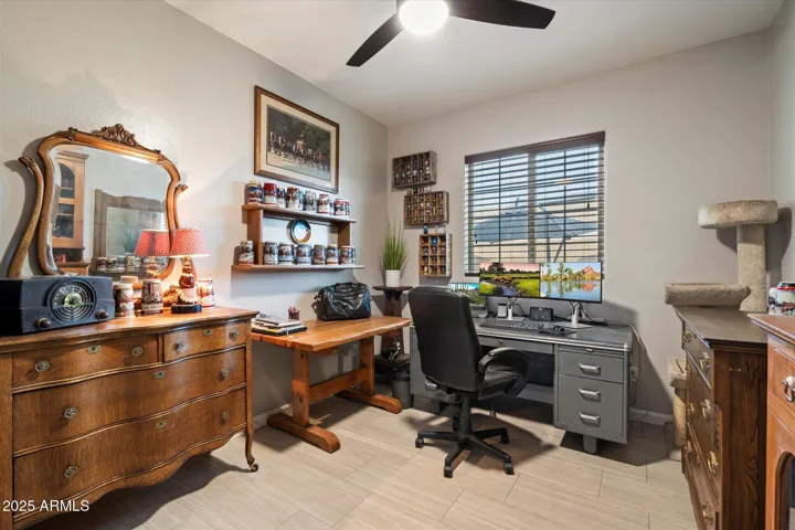 This versatile room functions perfectly as a bedroom or home office, featuring tile flooring, ceiling fan, and natural light. Ideal for remote work or guests, it enhances the flexible layout of this Peoria property.