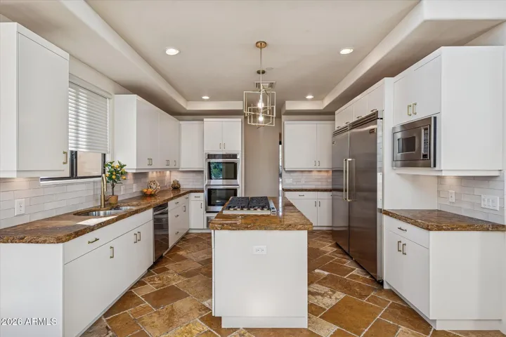 Freshly painted Crisp White Cabinetry, Stainless Wolff Appliances and Chiseled granite counters elevate this gourmet kitchen