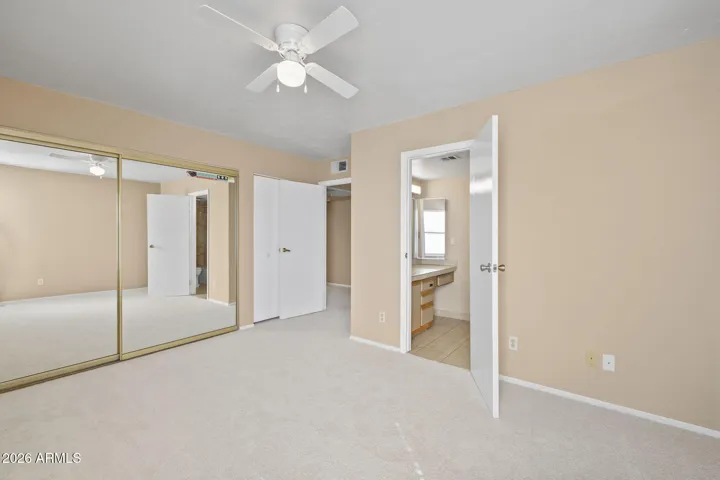 Primary bedroom with mirrored closet doors and attached bath.